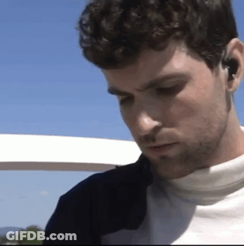 Bearded Man With Earbuds Looking Down GIF