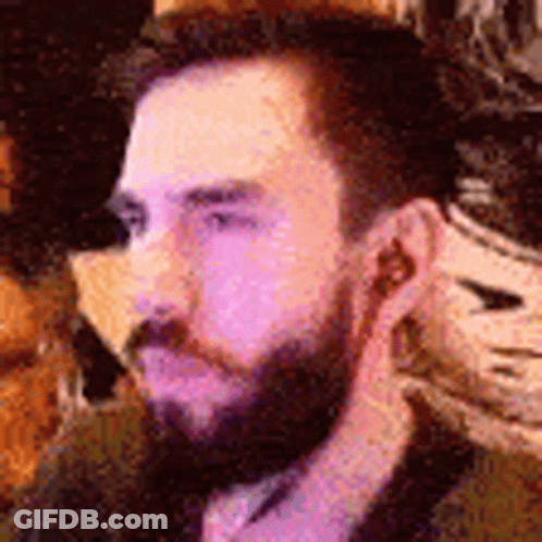 Bearded Man With Earbuds Sitting At Table GIF