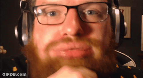 Bearded Man With Glasses And Headphones Looking At Camera GIF