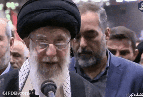 Bearded Man With Glasses At Microphone With Foreign Text GIF
