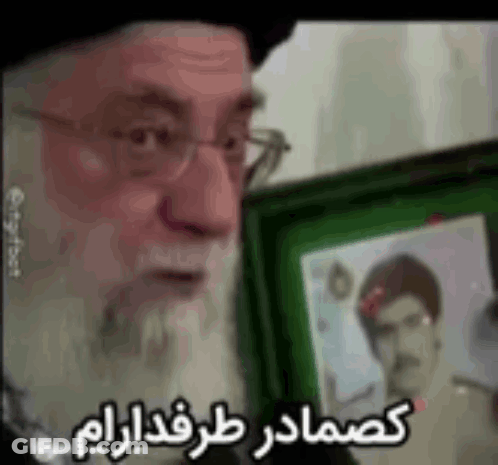 Bearded Man With Glasses Holding Picture In Green Frame GIF