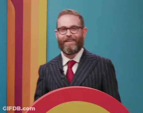 Bearded Man With Glasses Smiling At Podium GIF