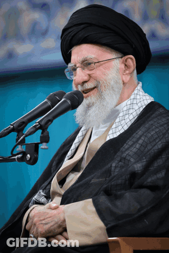 Bearded Man With Glasses Smiling Into Two Microphones GIF