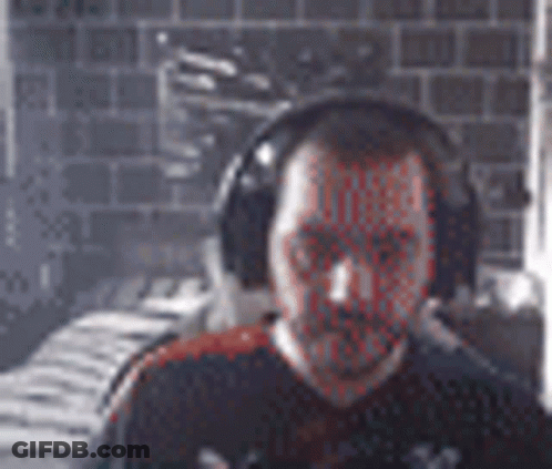 Bearded Man With Headphones By Brick Wall GIF