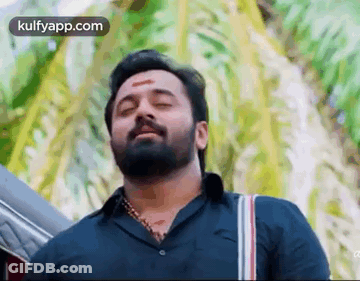 Bearded Man With Red Forehead Spot By Palm Tree GIF