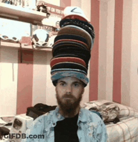 Bearded Man With Stack Of Hats GIF