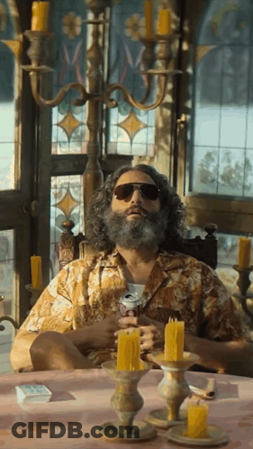 Bearded Man With Sunglasses At Candlelit Table GIF