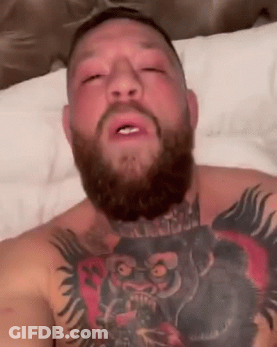 Bearded Man With Tattoos Lying On Bed GIF