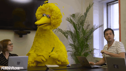 Big Bird From Sesame Street Sits At A Table With A Man And Woman GIF