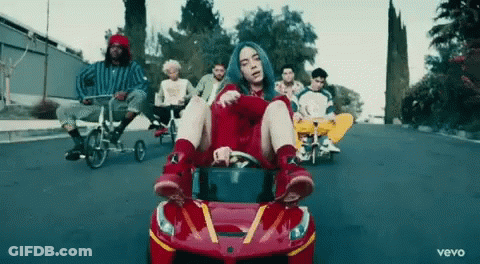 Billie Eilish Driving Red McDonald's Car With Group Riding Bikes Behind GIF