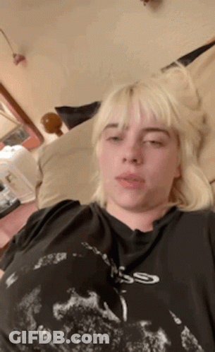 Billie Eilish Laying On Bed In Black Skull T-Shirt GIF