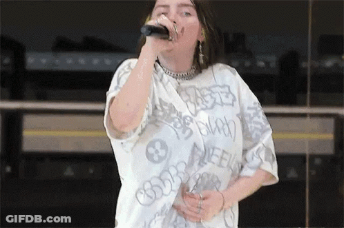 Billie Eilish Singing Into Microphone With White Shirt GIF