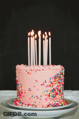 Birthday Cake With Pink Frosting And Sprinkles And Lit Candles GIF