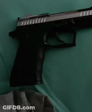 Black And Silver Gun On Green Cloth GIF