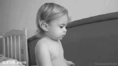 Black And White Baby Sitting On Bed GIF