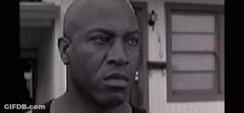 Black And White Bald Man Looking At Camera Before House GIF