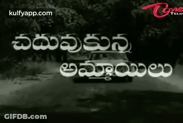 Black And White Car Driving Down Road With Telugu Writing GIF
