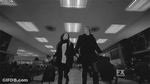 Black And White Couple Holding Hands At Airport GIF