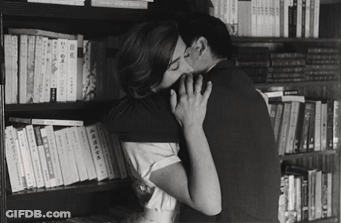 Black And White Couple Kissing By Bookshelf GIF