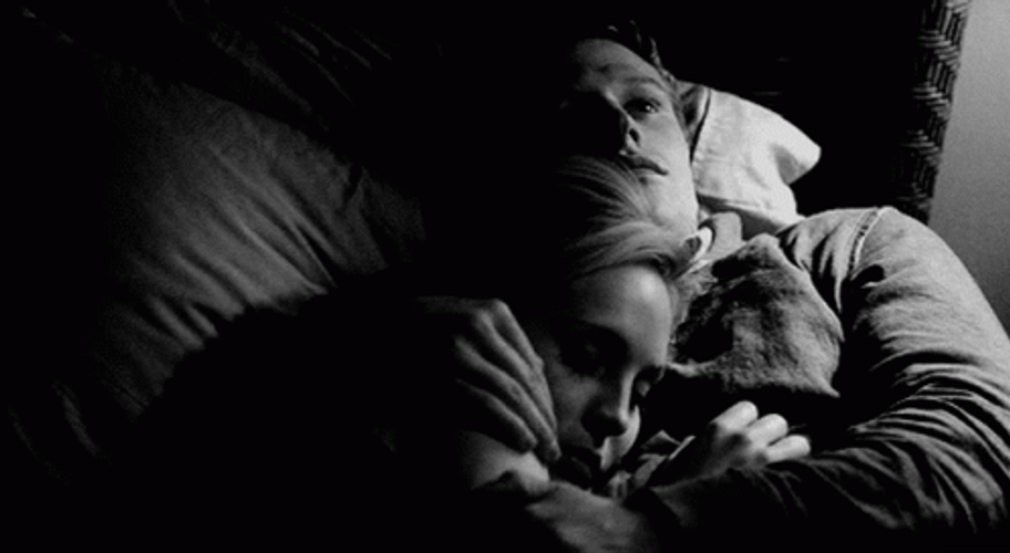 Black And White Couple Snuggles On Bed GIF