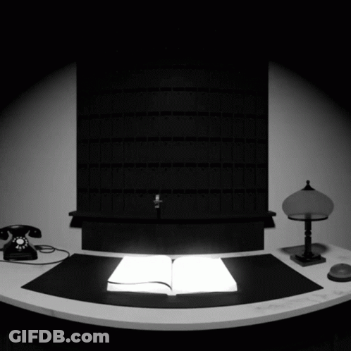 Black And White Desk With Open Book And Lamp GIF