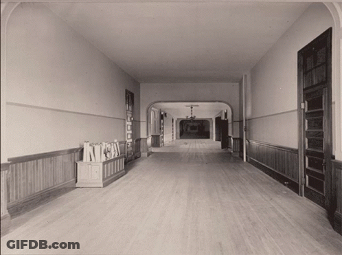 Black And White Hallway With Bookshelf Saying A GIF
