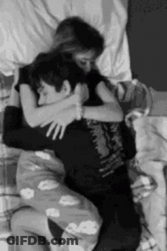 Black And White Man And Woman Hugging In Bed GIF