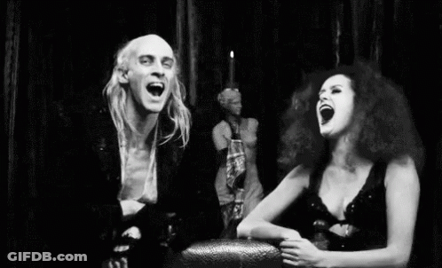 Black And White Man And Woman Laughing In Front Of Statue GIF