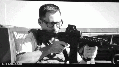 Black And White Man Holding Gun By Bottle Truck GIF