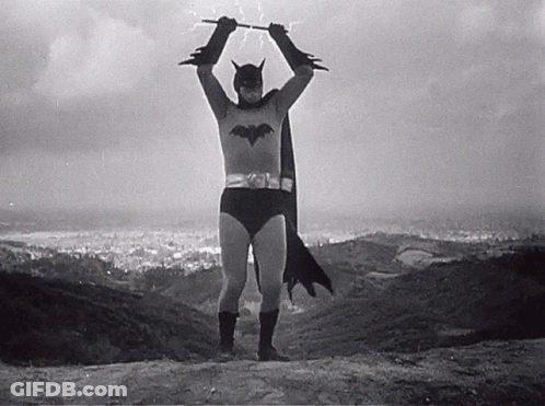 Black And White Man In Batman Costume Holding Bat GIF