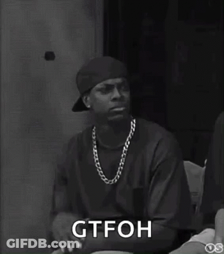 Black And White Man In Hat And Necklace Sitting In Chair GIF