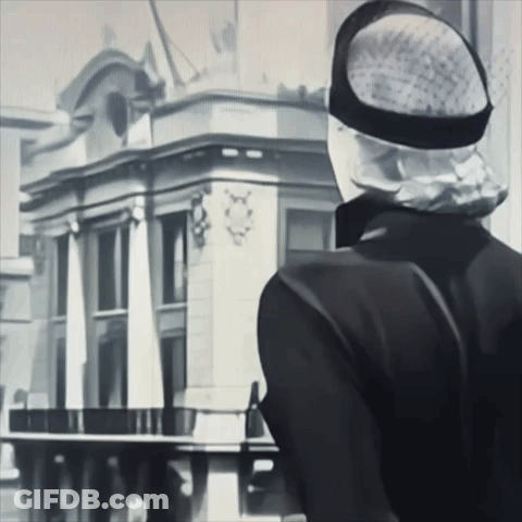 Black And White Man In Hat Looking At Building GIF