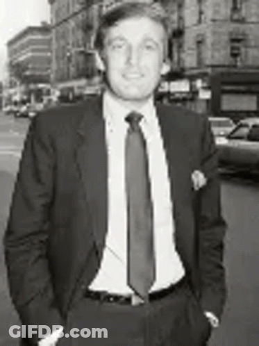 Black And White Man In Suit And Tie On City Street GIF