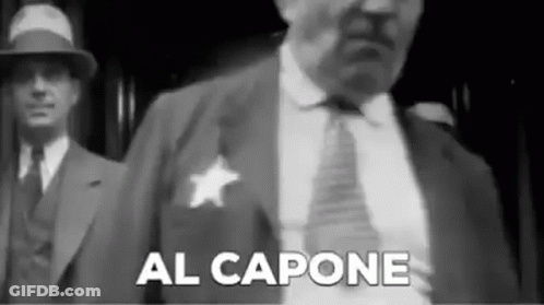 Black And White Man In Suit And Tie With Sheriff's Badge GIF