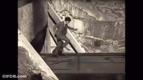Black And White Man In Suit Standing On Railing GIF