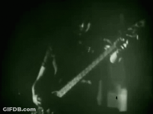 Black And White Man Playing Guitar In Dark Room GIF