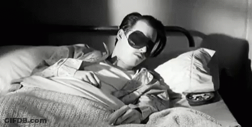 Black And White Man Sleeping In Bed With Blindfold GIF