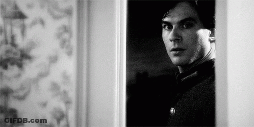 Black And White Man Standing In Doorway Looking Out GIF