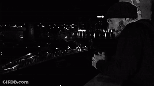 Black And White Man Walking Across Bridge With Graffiti GIF