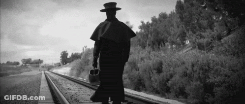 Black And White Man Walking On Train Tracks GIF