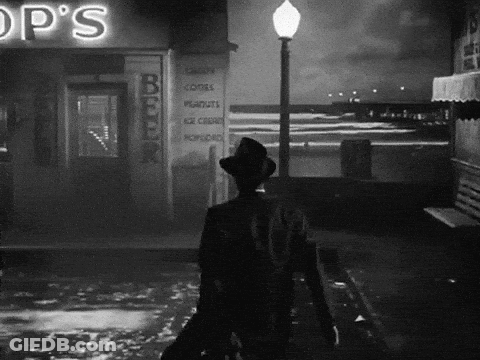 Black And White Man Walking Past Op's Shop GIF