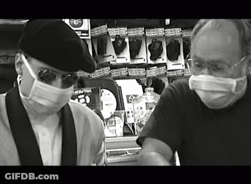 Black And White Men In Masks Near Remote Controls GIF