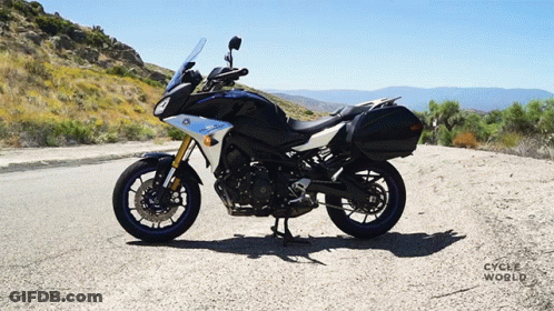 Black And White Motorcycle Parked On Road With Cycle World GIF