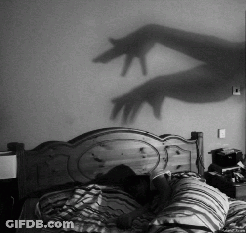 Black And White Person Laying On Bed With Hand Shadow GIF