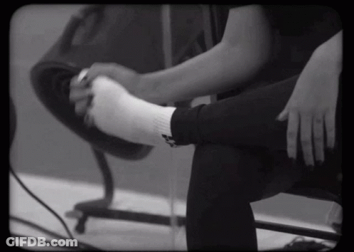 Black And White Person Putting On White Socks GIF