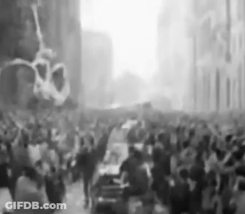 Black And White Photo Of Crowd Walking Down City Street GIF
