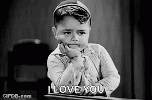 Black And White Photo Of Little Boy With Hand On Chin At Desk GIF