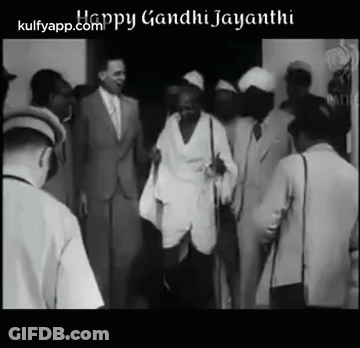 Black And White Photo Of Mahatma Gandhi Walking Through Crowd GIF