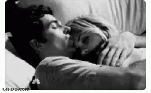 Black And White Photo Of Man And Woman Kissing In Bed GIF