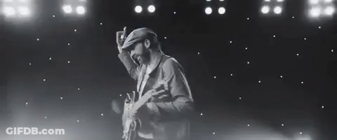 Black And White Photo Of Man Holding Guitar On Stage GIF